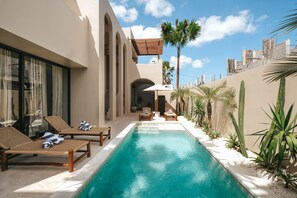 A poolside area with lounge chairs, a small pool, and palm trees. - Limón & Cello Villa (Canggu)