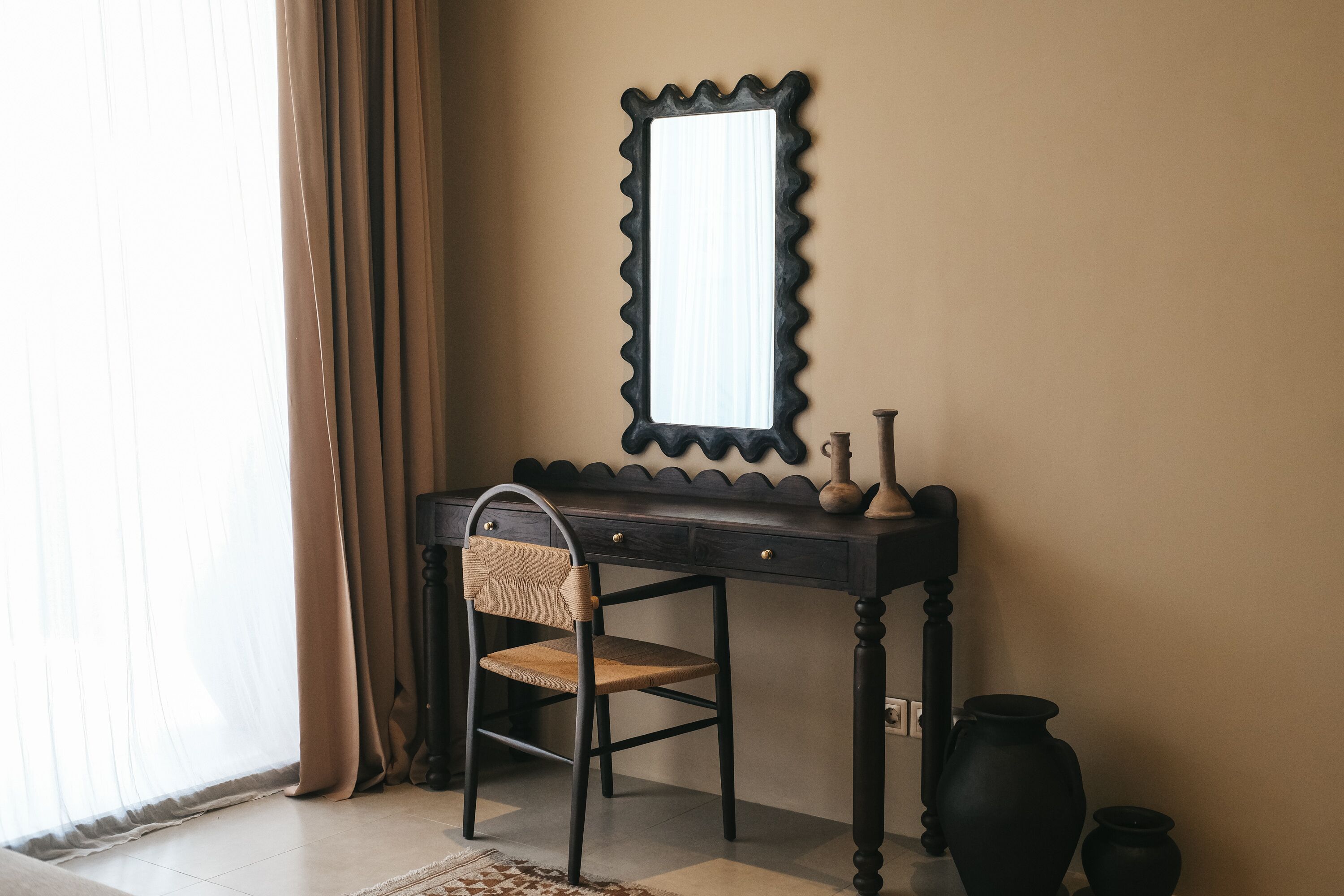A room with a desk, chair, and a mirror.