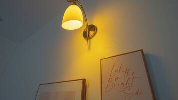 A wall-mounted lamp with a deer head design, two framed artworks, and a handwritten message.