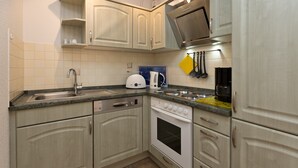 A kitchen with light-colored cabinets, a stainless steel sink, a built-in oven, and a microwave. - Holiday Apartment 'Maribell' with Lake View, Balcony and Wi-Fi (Jabel)