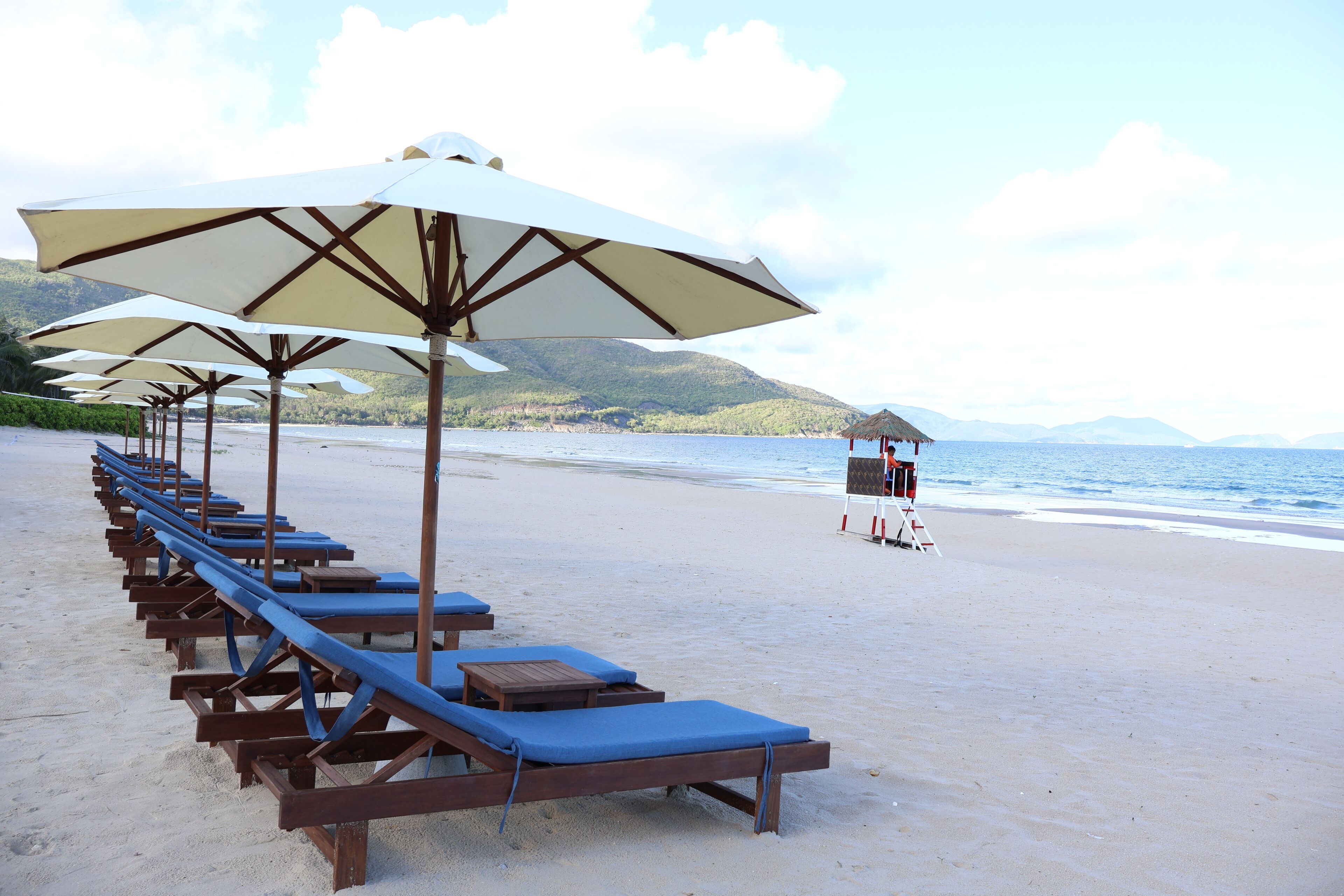 Playa privada, arena blanca, sillas reclinables de playa, sombrillas
