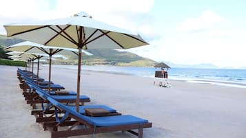 Playa privada, arena blanca, sillas reclinables de playa, sombrillas