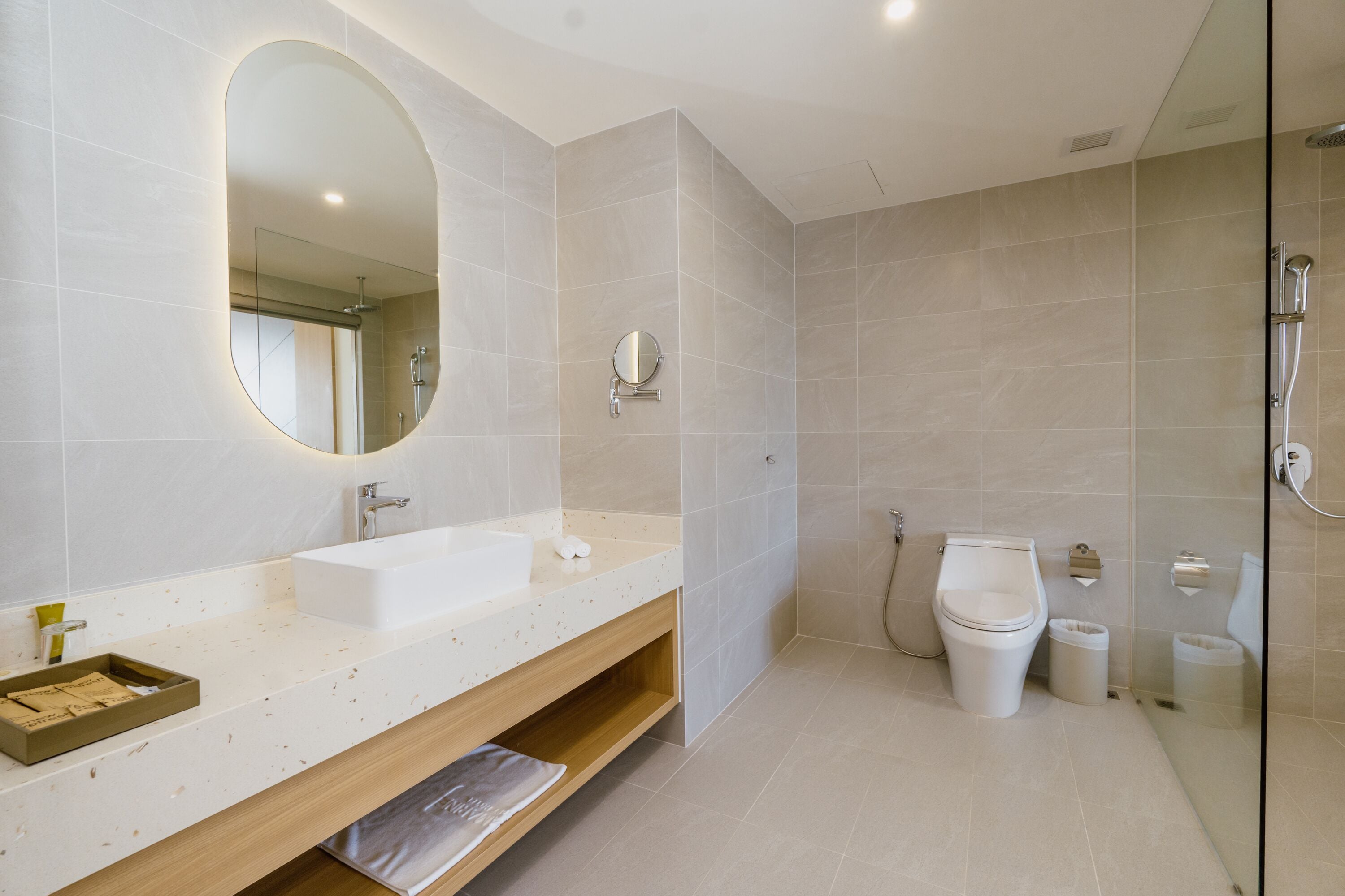 Une salle de bain moderne avec un grand miroir, un lavabo, des toilettes et une douche.