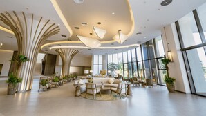 Un hall d’entrée spacieux, doté de meubles modernes, de grandes fenêtres et d’un décor de plafond original.