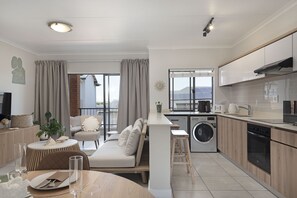 A modern apartment with a living area, kitchenette, and balcony. - Ballito Hills Unit 79 (Ballito)