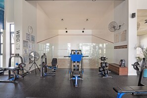 A gym with various exercise equipment, including a squat rack, bench press, and weight machines.