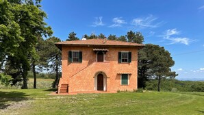 A single-story building with a tiled roof, a central entrance, and a small porch. - Quercia 1 - Relax in Tuscany (Montaione)