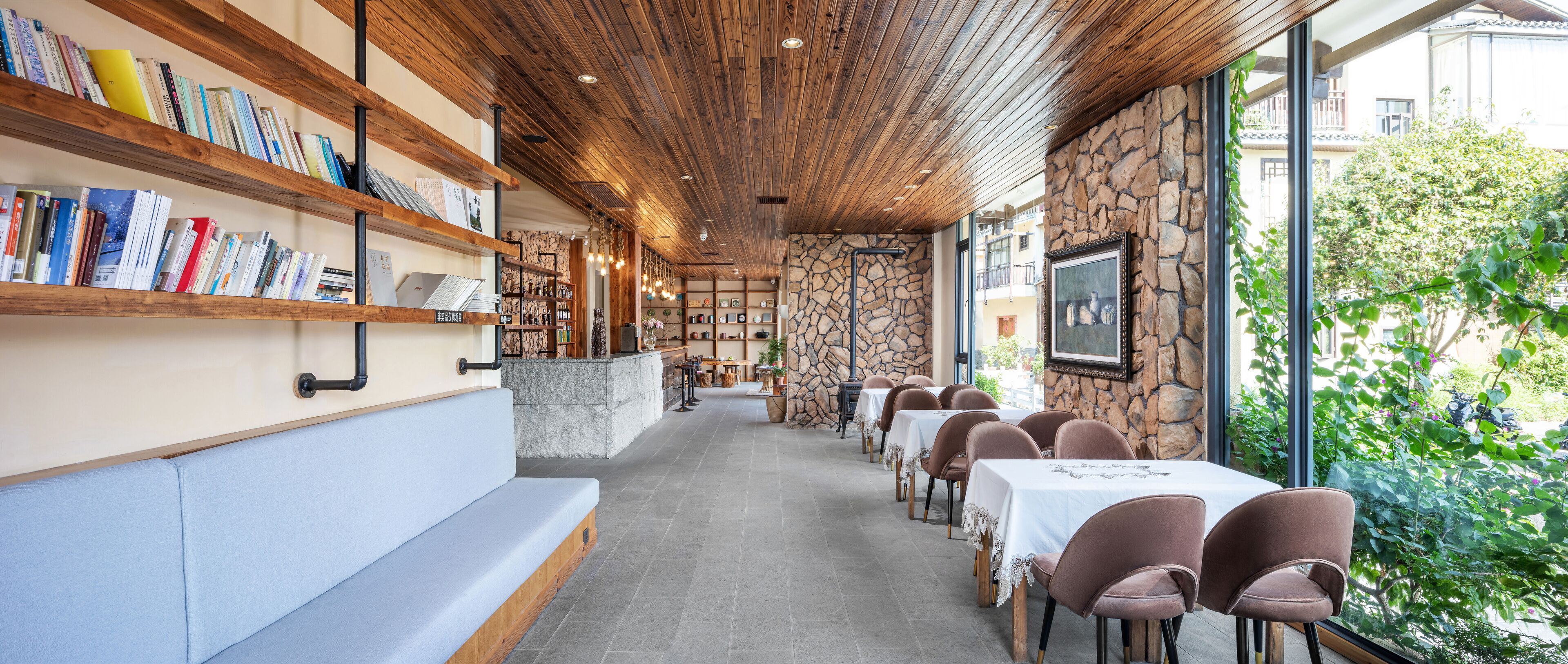 Un restaurant avec des étagères en bois, des murs en pierre et un long comptoir.