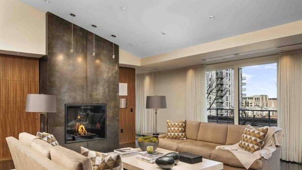 A modern living room with a fireplace, two sofas, a coffee table, and large windows offering a city view. - Luxury Penthouse Living, Breathtaking Views, Huge Wraparound Deck, All New Decor, Two Parking Spots (Portland)