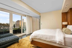 A modern hotel room with a large bed, a sofa, and a balcony with a city view. - Luxury Penthouse Living, Breathtaking Views, Huge Wraparound Deck, All New Decor, Two Parking Spots (Portland)