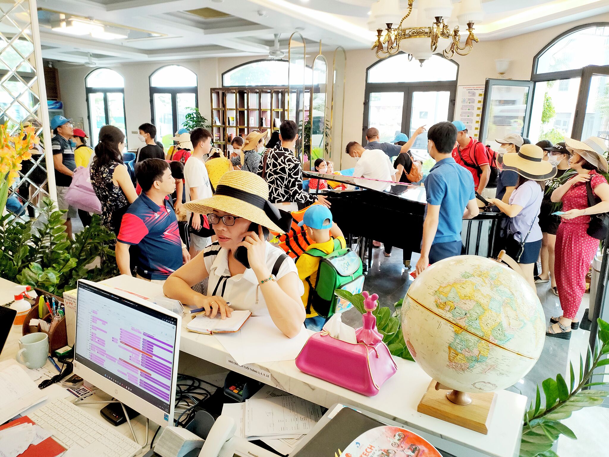 A busy indoor space with a desk, computer, and a globe.