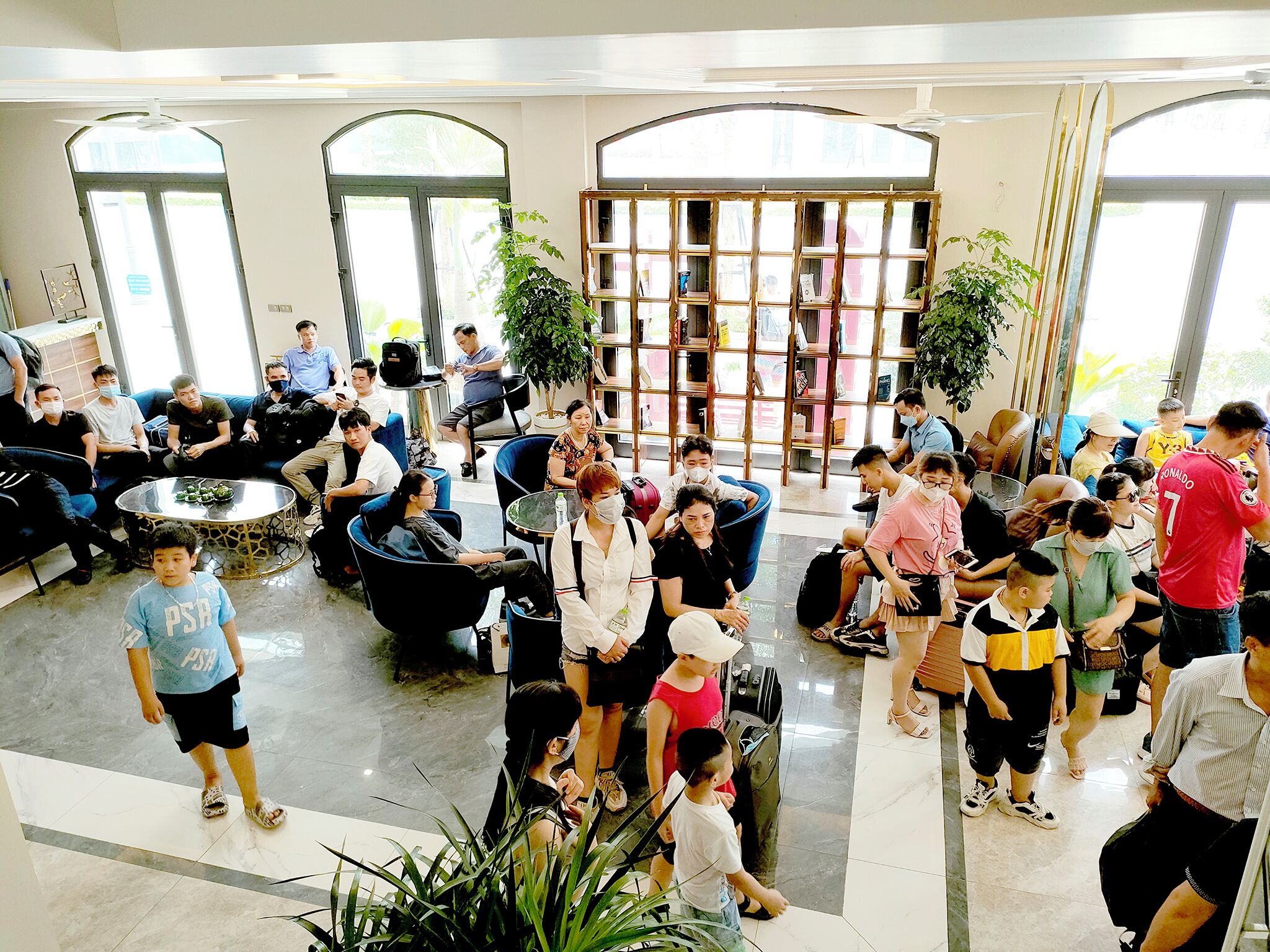 A spacious lobby with seating areas, a central coffee table, and a bookshelf.