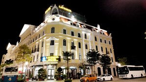 Un hotel con un cartel llamativo que dice "Lavender Hotel" y un gran letrero iluminado sobre la entrada.