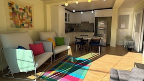 A modern living room with a sofa, a colorful rug, and a dining area with chairs and a table. - Hongdae Private Guesthouse (Seoul)