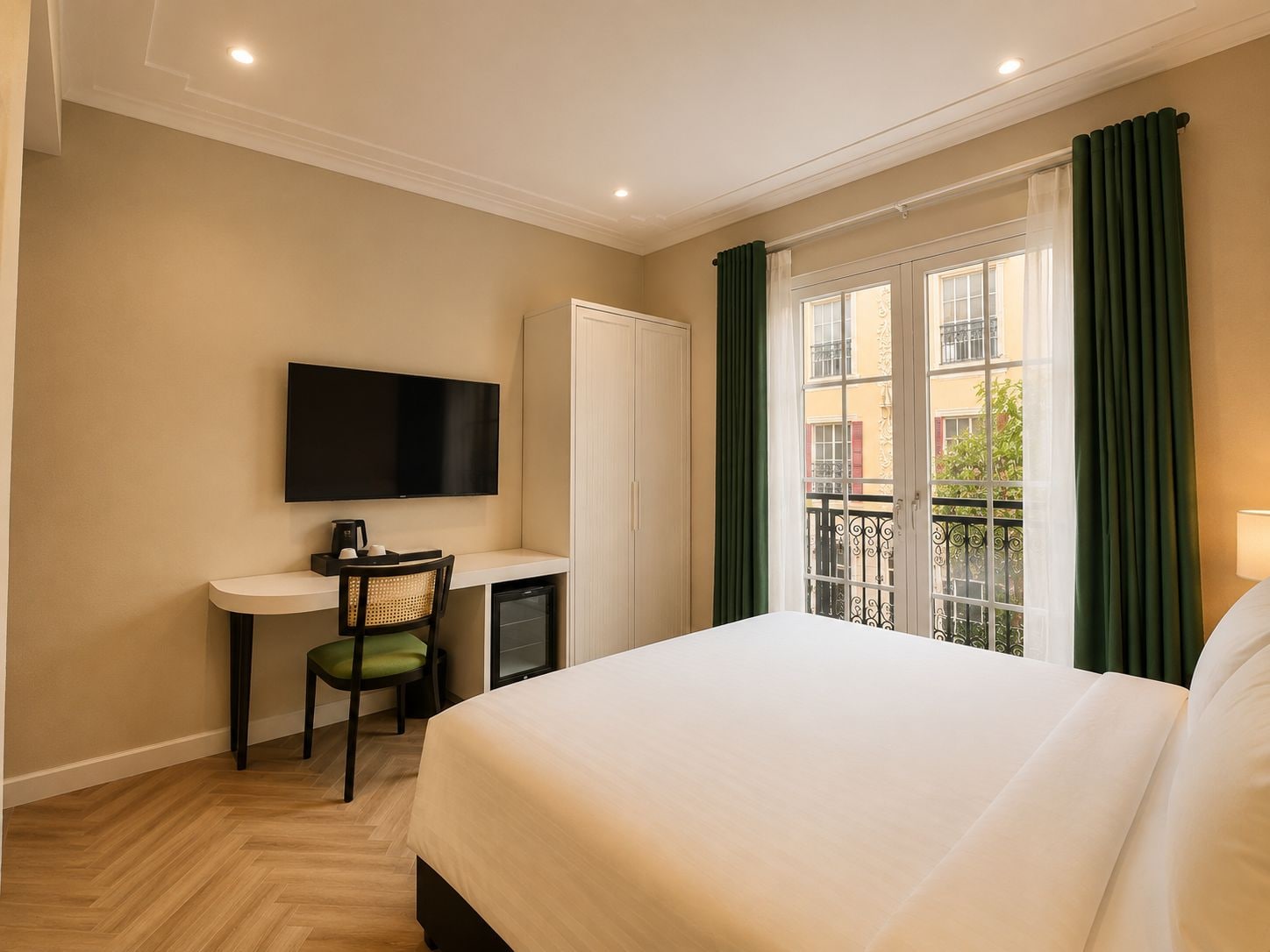 Une chambre d’hôtel avec un lit, un bureau et une chaise, une télévision et une fenêtre avec des rideaux.