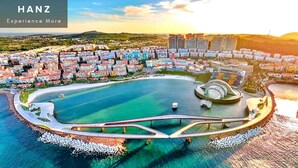 A coastal cityscape with a prominent marina, a bridge, and residential buildings. - HAN Lagoon Sunset Hotel (Phu Quoc)