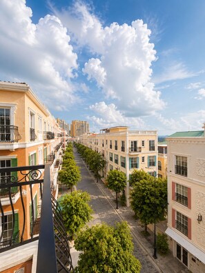 A row of buildings with balconies, a clear sky, and trees lining the street. - HAN Sunset Milan Hotel & Spa (Phu Quoc)