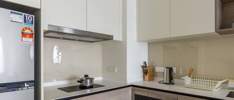 A modern kitchen with a stainless steel refrigerator, a built-in oven, and a microwave.