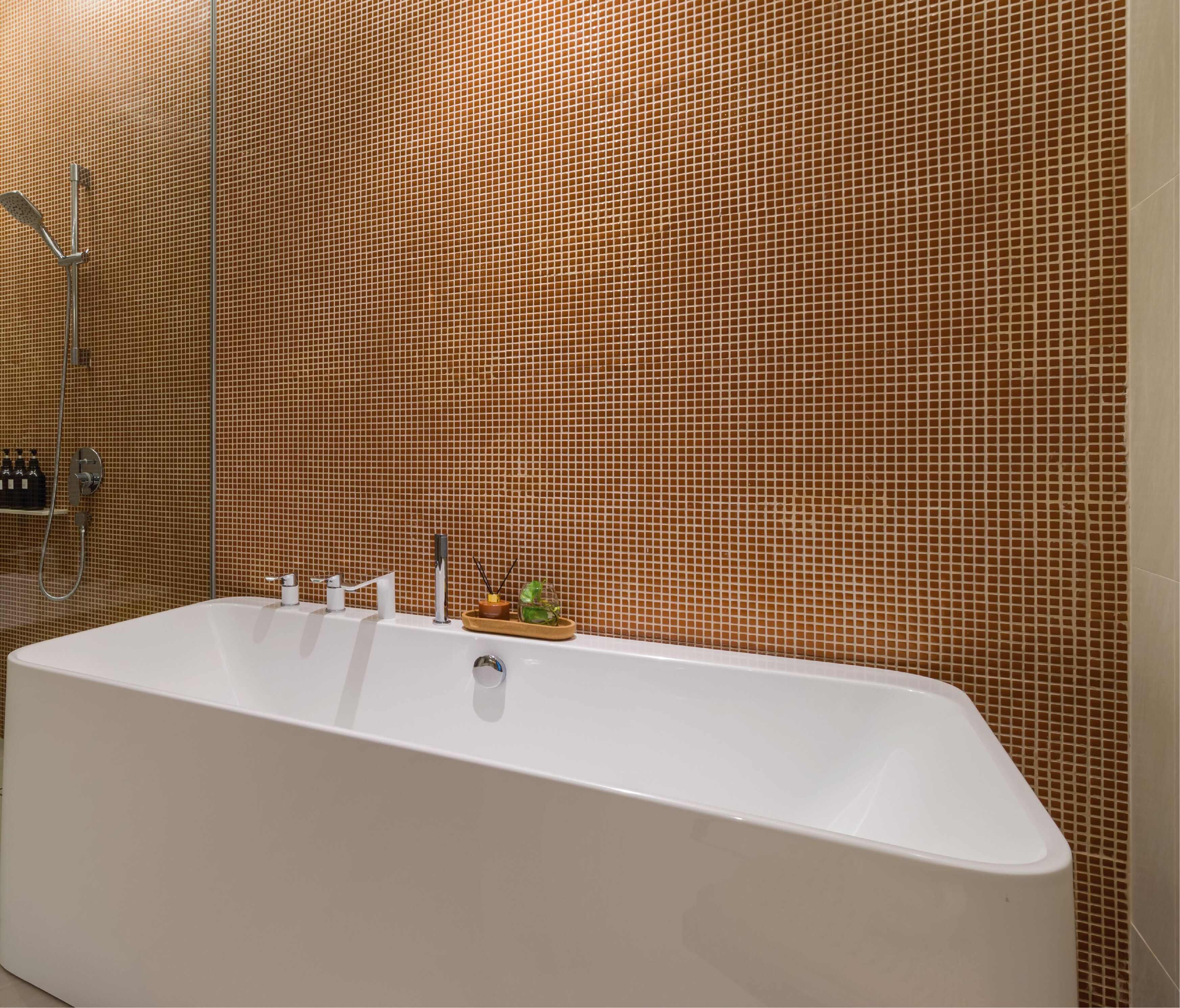 Une salle de bain moderne avec une grande baignoire, une douche et un mur recouvert de carreaux.