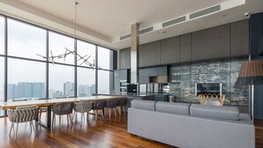 Una cocina moderna con una isla grande, un comedor con sillas y un sofá gris.