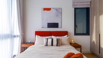Een moderne slaapkamer met een rode hoofdbord, een groot abstract schilderij, een nachtkastje met een lamp en een raam met gordijnen.