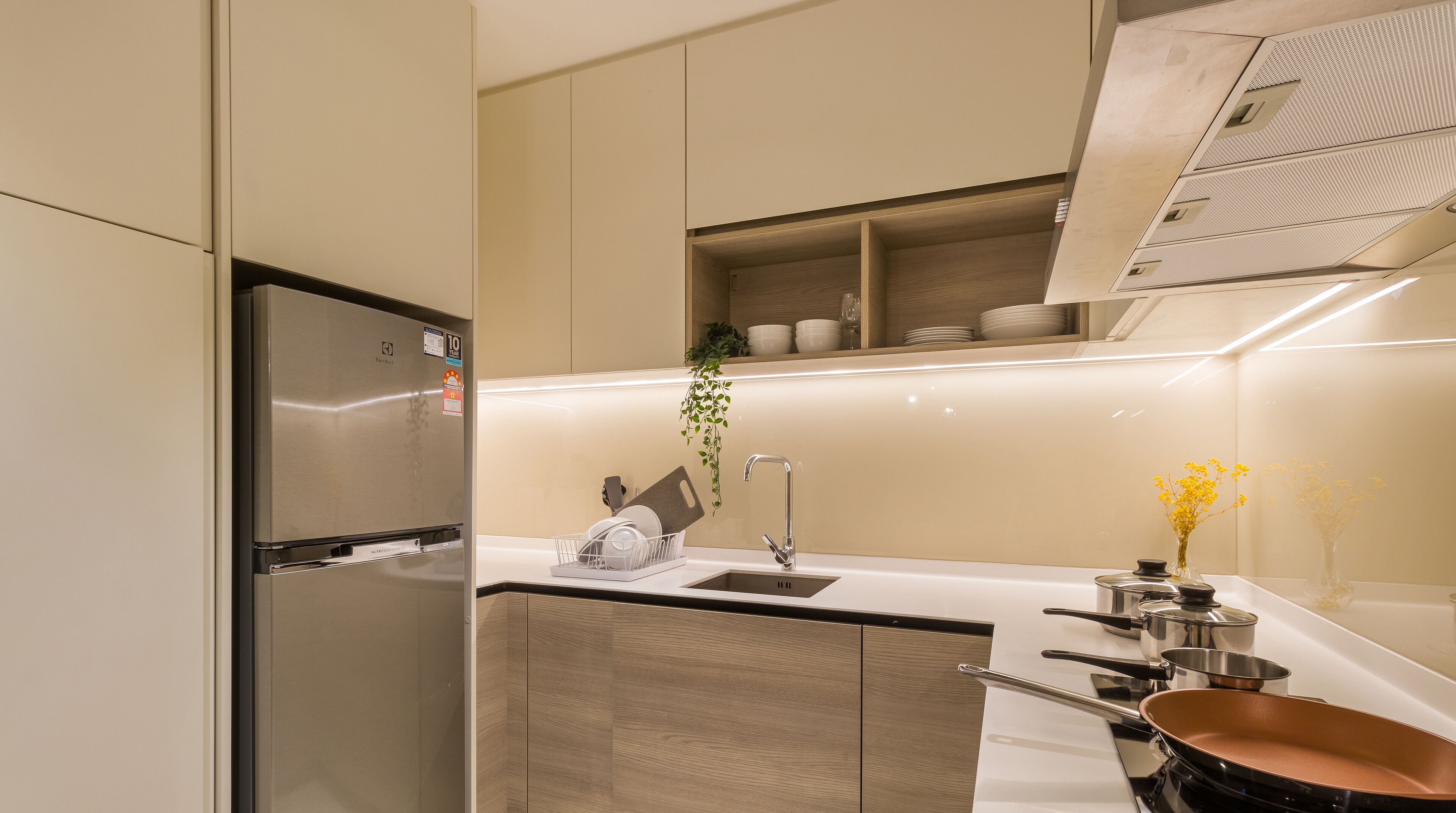 A modern kitchen with a built-in refrigerator, a sink, and a stove.