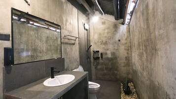 Une salle de bain moderne avec un grand miroir, un lavabo et des toilettes.