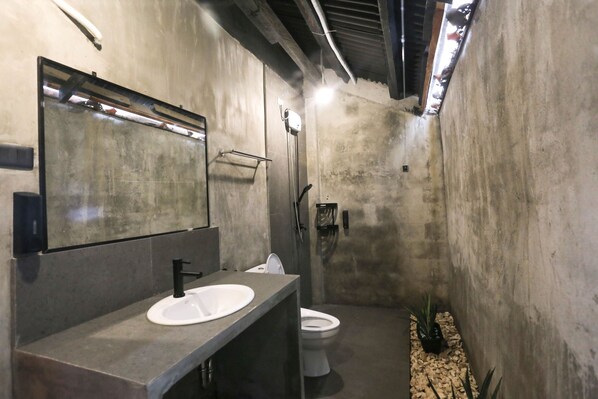 A modern bathroom with a large mirror, a sink, and a toilet. - Marika Resort (Badian)