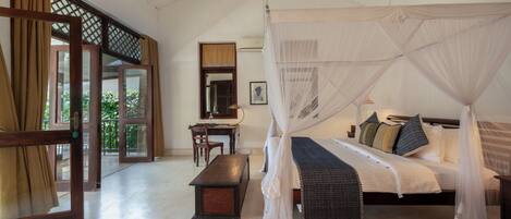 Une chambre à coucher avec un lit à baldaquin, un bureau et une chaise.