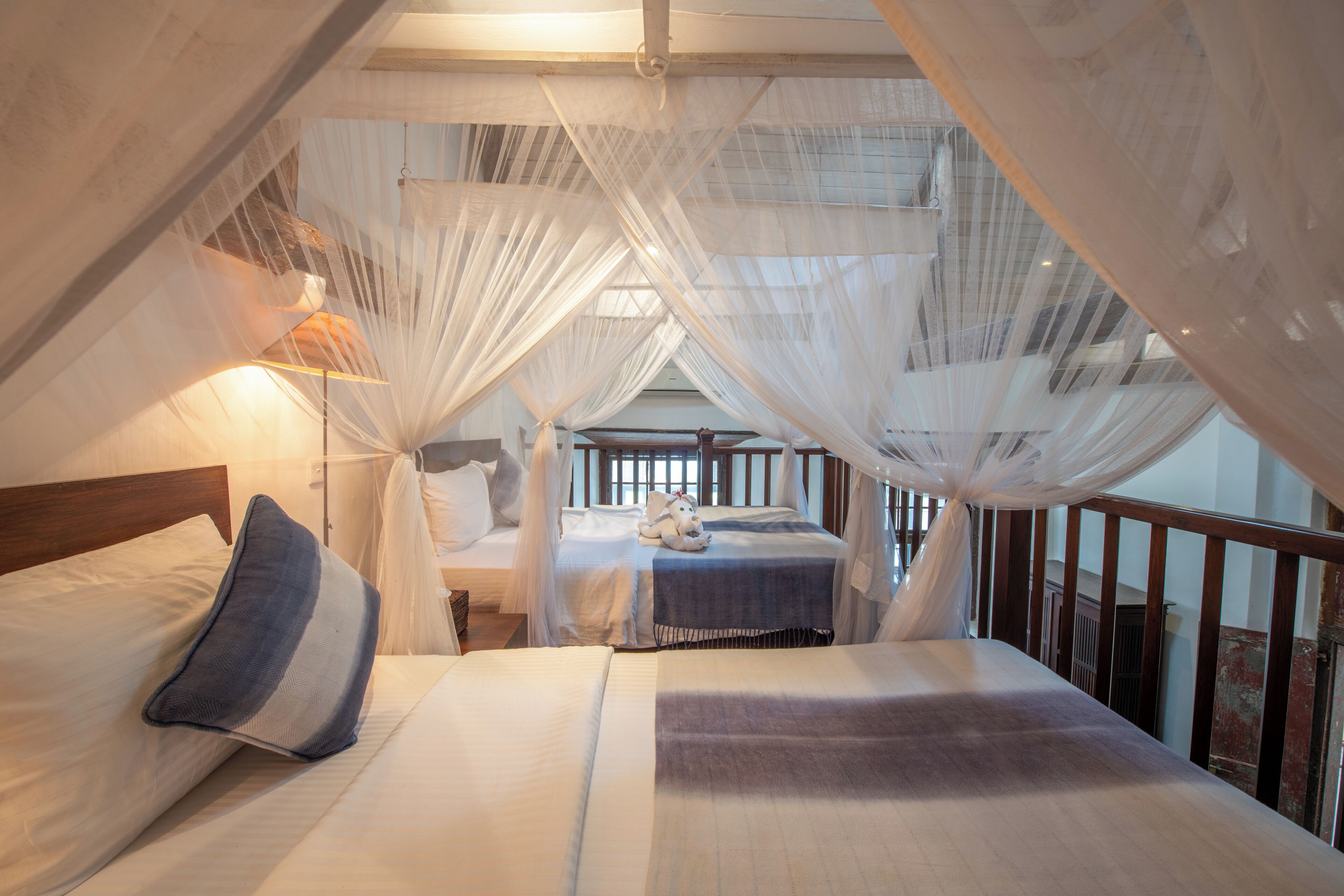 A room with a bed, a nightstand, a lamp, and a window.