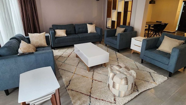 A modern living room with a sofa set, a coffee table, and a rug.