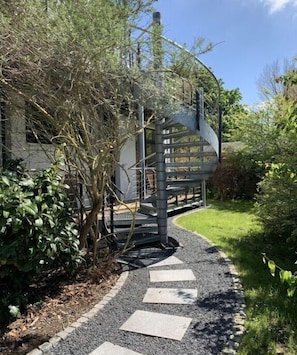 Stroll up the modern staircase surrounded by lush gardens and a serene atmosphere.