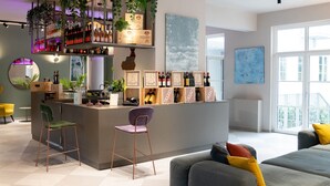 A modern bar area with shelves of bottles, a bar counter, and two chairs. - Il Santo Stays (Florence)