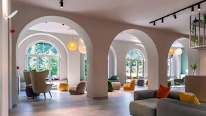 A spacious lobby with arched ceilings, a checkered floor, and a grey sofa with colorful cushions. - Il Santo Stays (Florence)