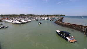 A marina with multiple boats docked, a wooden breakwater, and a clear sky. - 1 Star Cottages (Freshwater)