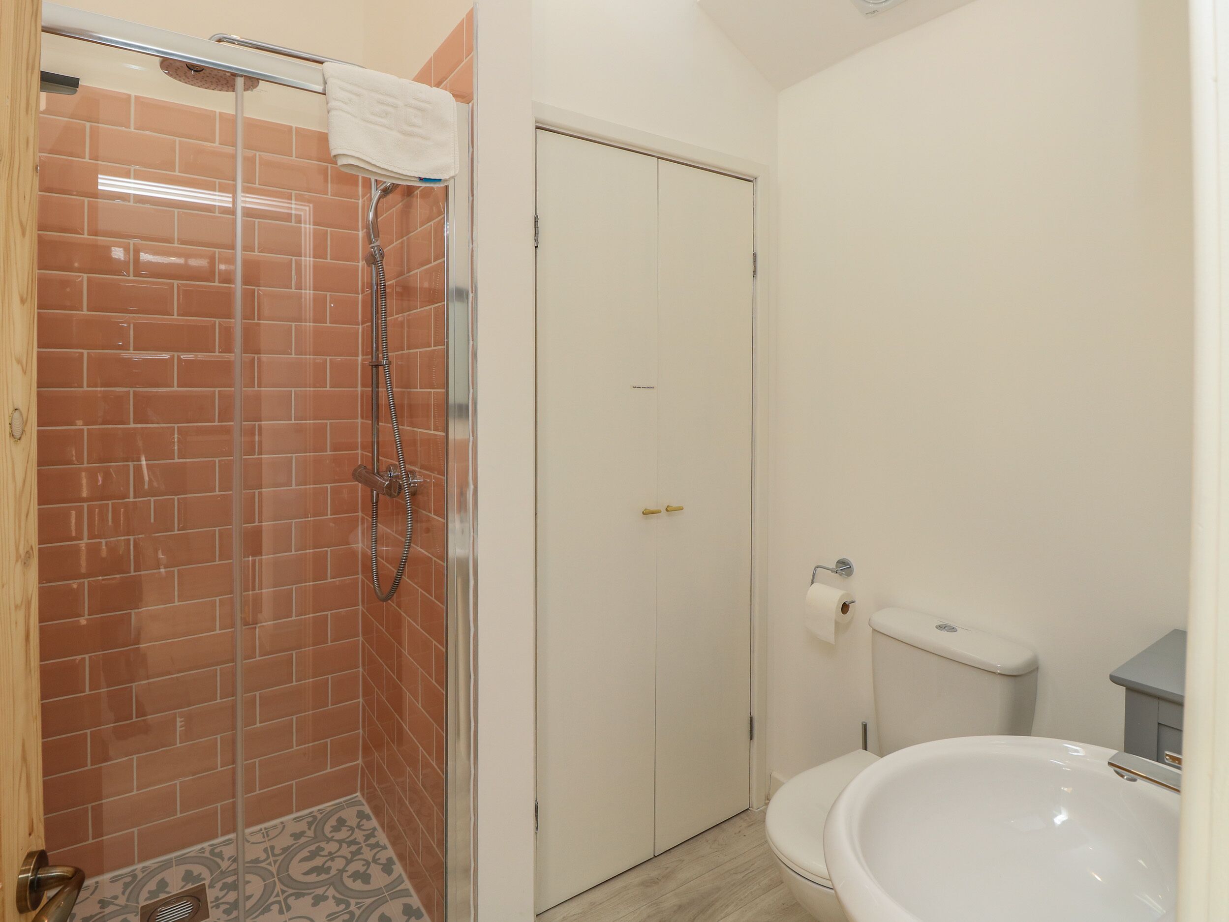 Een badkamer met een douche, toilet en wastafel.
