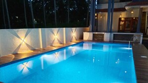 A rectangular swimming pool with a wooden deck and a low wall with geometric patterns. - FIGO BEACH RESORT (Varkala)