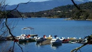 A marina with boats docked, a covered area, and a mountainous backdrop.