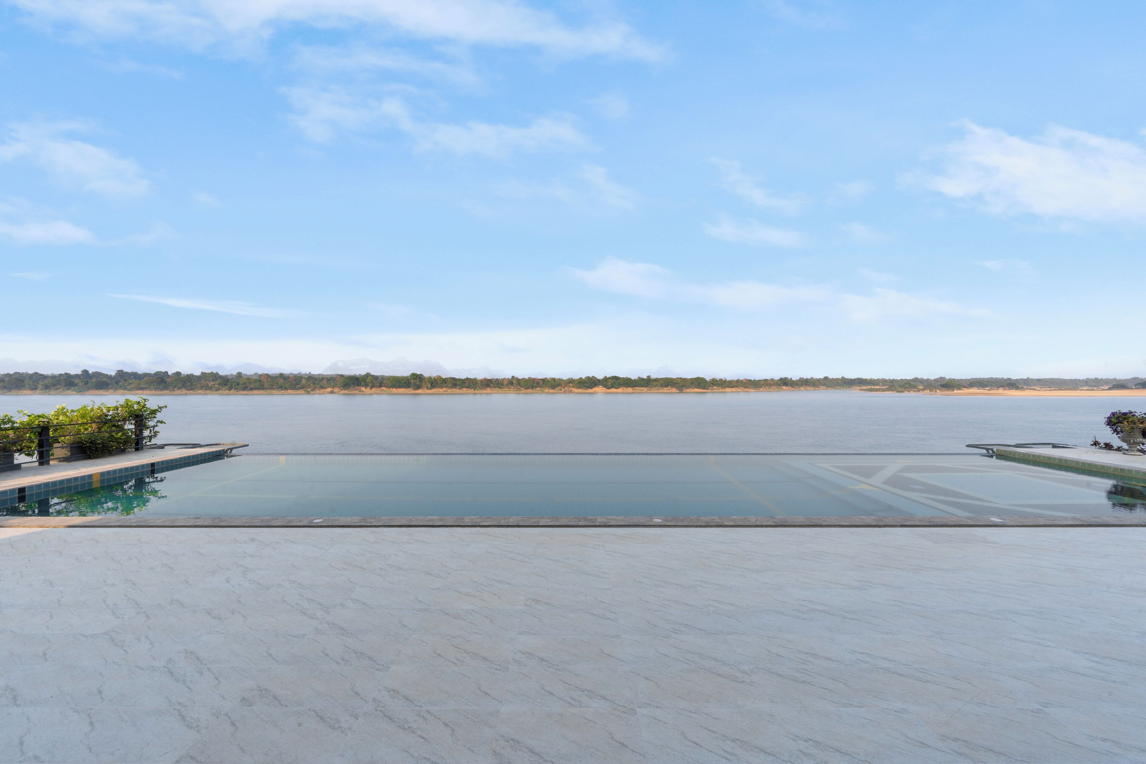 A large, open swimming pool with a clear view of the surrounding landscape and distant mountains.