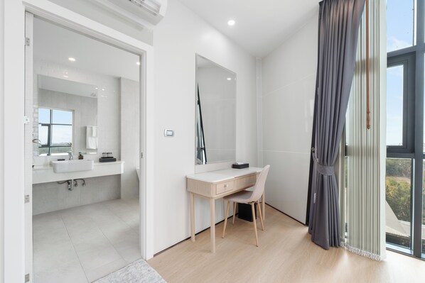 A modern bathroom with a large mirror, a sink, and a wooden desk. - NAKA-RAJ Escape Hotel (Nakhon Phanom)
