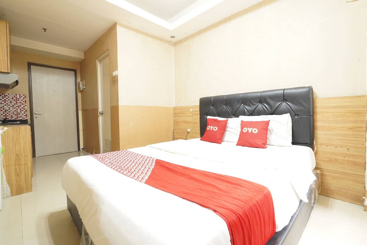 A hotel room with a bed, a wardrobe, and a door.