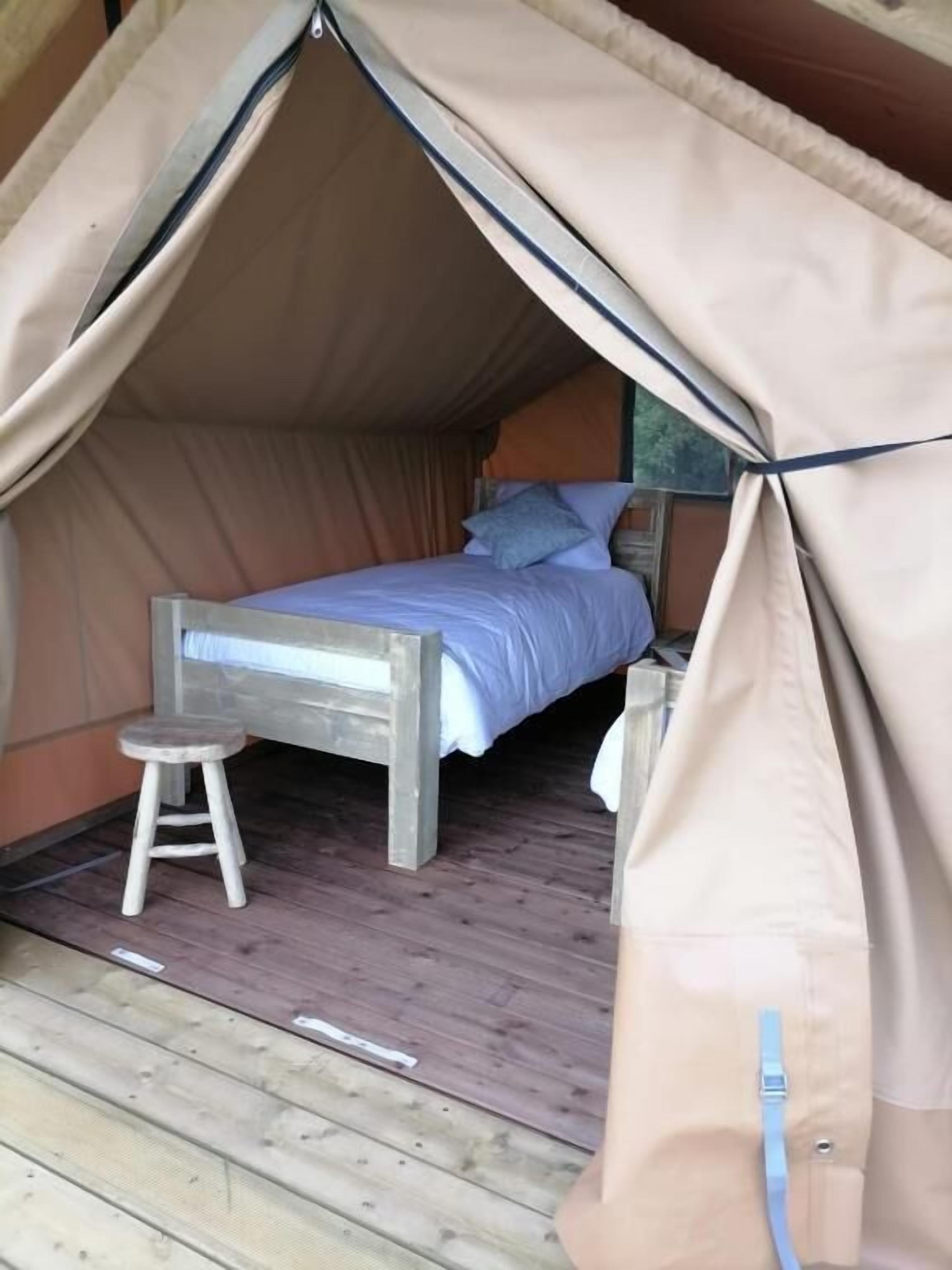 Una cama individual con dosel en una habitación tipo tienda.