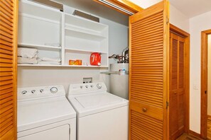 A laundry area with two white washers and dryers, wooden louvered doors, and a shelf with folded towels and a red kettle. - Located in the Castle Glen Estates! Recently Remodeled Master! Pet Friendly! Pool Table! Foosball! (Big Bear Lake)