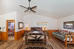 A bedroom with a rustic wooden bed, a ceiling fan, a window with blinds, and a framed picture on the wall. - Located in the Castle Glen Estates! Recently Remodeled Master! Pet Friendly! Pool Table! Foosball! (Big Bear Lake)