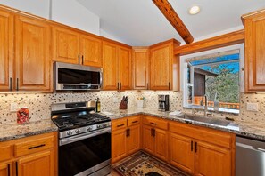 A kitchen with wooden cabinets, stainless steel appliances, and a window with a view. - Located in the Castle Glen Estates! Recently Remodeled Master! Pet Friendly! Pool Table! Foosball! (Big Bear Lake)