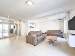 A modern living room with a sofa, a coffee table, and a TV.