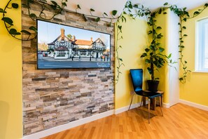 Relax in this serene space with a mounted TV and a potted plant.