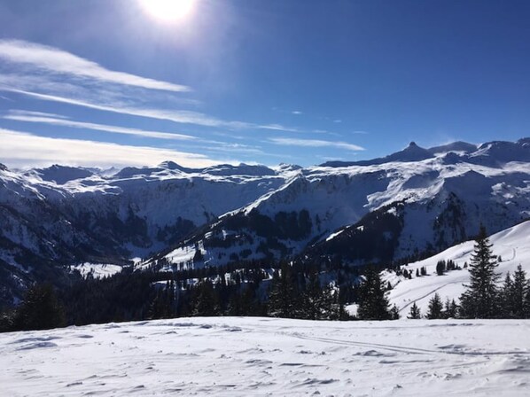 A snowy mountain landscape with clear skies and distant peaks.