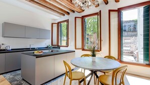 Una cocina moderna con una isla central, vigas de madera y ventanas amplias.