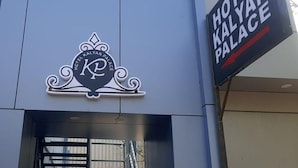 A sign for Hotel Kalyan Palace with a prominent logo and directional arrow. - Hotel Kalyan Palace (Ahmedabad)
